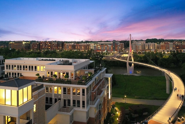 aerial view at dusk featuring a view of city and a water view