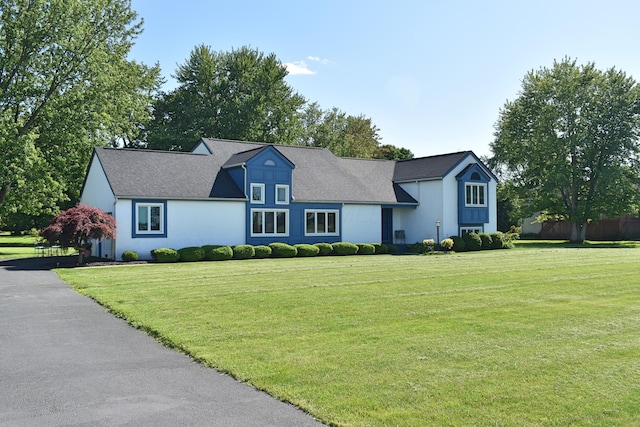 view of front of house with stucco siding and a front lawn