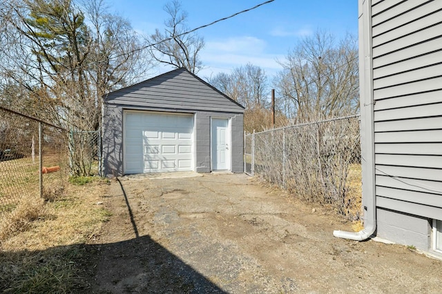 detached garage with concrete driveway and fence