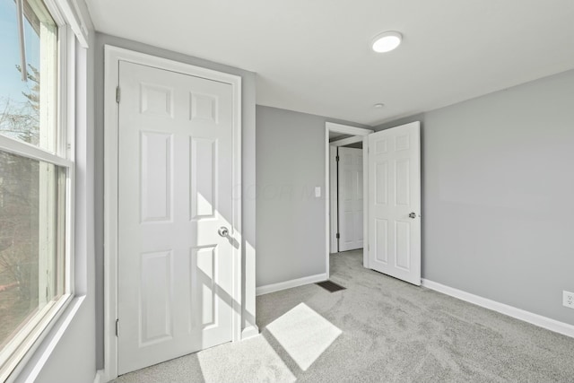 unfurnished bedroom featuring visible vents, baseboards, and carpet floors