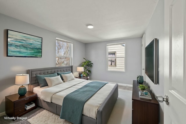 bedroom featuring baseboards and multiple windows