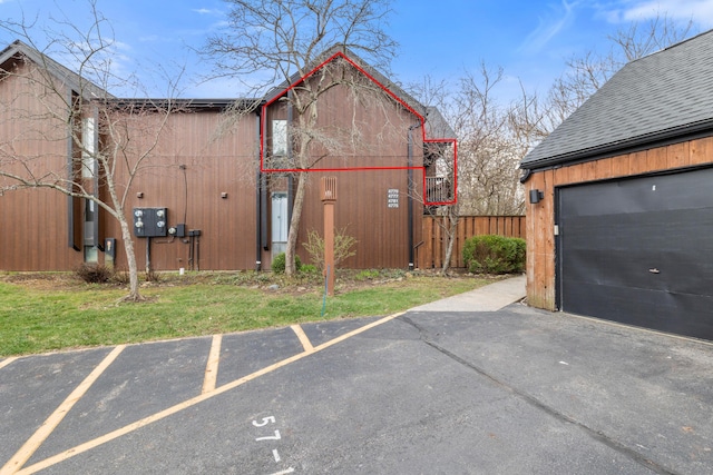 exterior space with a shingled roof and fence