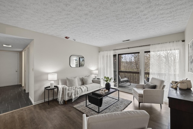 living room with baseboards, visible vents, wood finished floors, and a textured ceiling