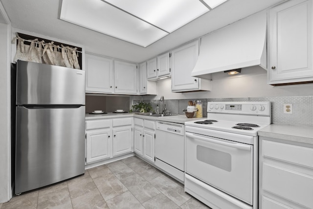 kitchen with white cabinets, light countertops, white appliances, a sink, and custom range hood