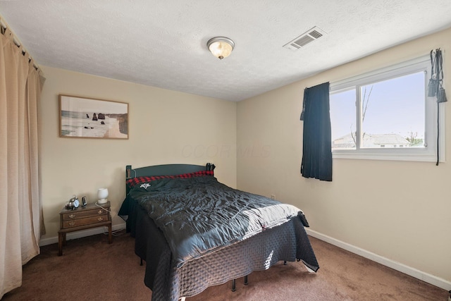 bedroom with baseboards, visible vents, carpet floors, and a textured ceiling