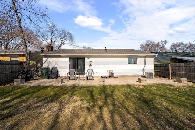 rear view of house with a yard, a fenced backyard, cooling unit, and a patio