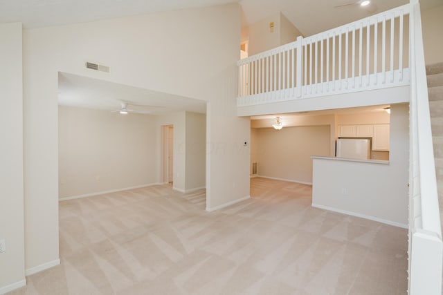 spare room featuring visible vents, baseboards, light colored carpet, and a ceiling fan