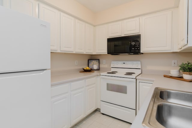 kitchen featuring white appliances, white cabinets, light countertops, and a sink