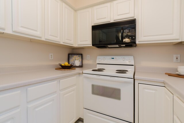 kitchen with white electric range oven, white cabinets, light countertops, and black microwave