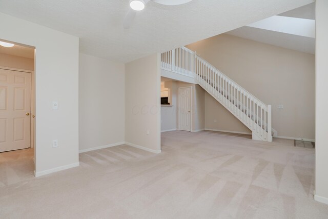 unfurnished living room featuring stairway, carpet, and baseboards