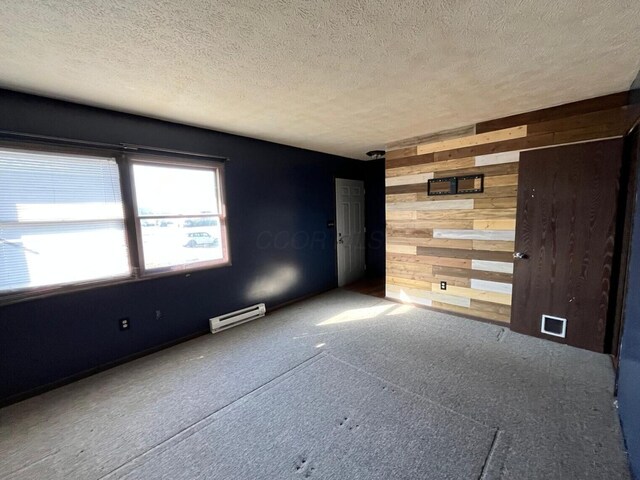 380 W Neff St, Morral, OH 43337 - spare room with visible vents, wood walls, a textured ceiling, and a baseboard heating unit
