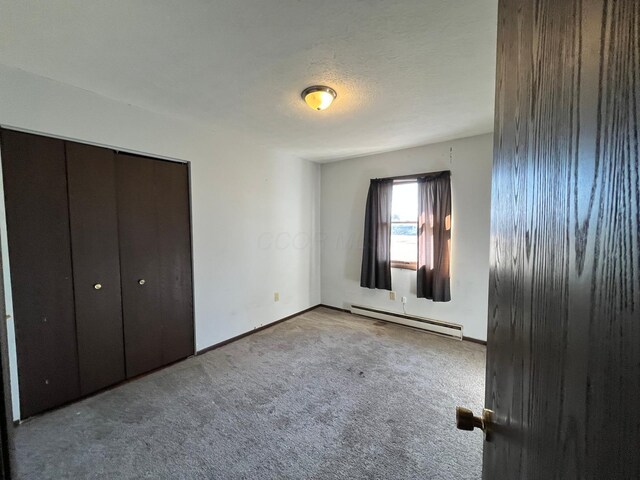 380 W Neff St, Morral, OH 43337 - unfurnished bedroom featuring a baseboard heating unit, a textured ceiling, a closet, carpet flooring, and baseboards
