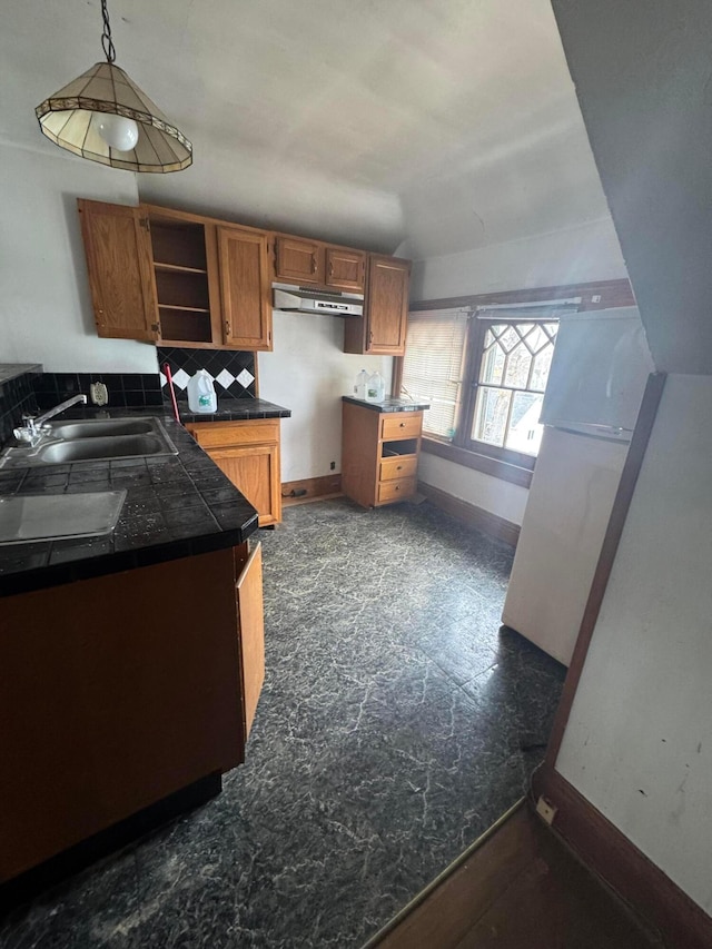 kitchen featuring brown cabinetry, baseboards, open shelves, a sink, and decorative light fixtures