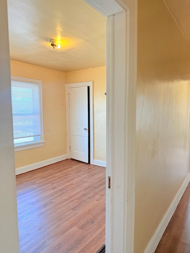 hall featuring wood finished floors and baseboards