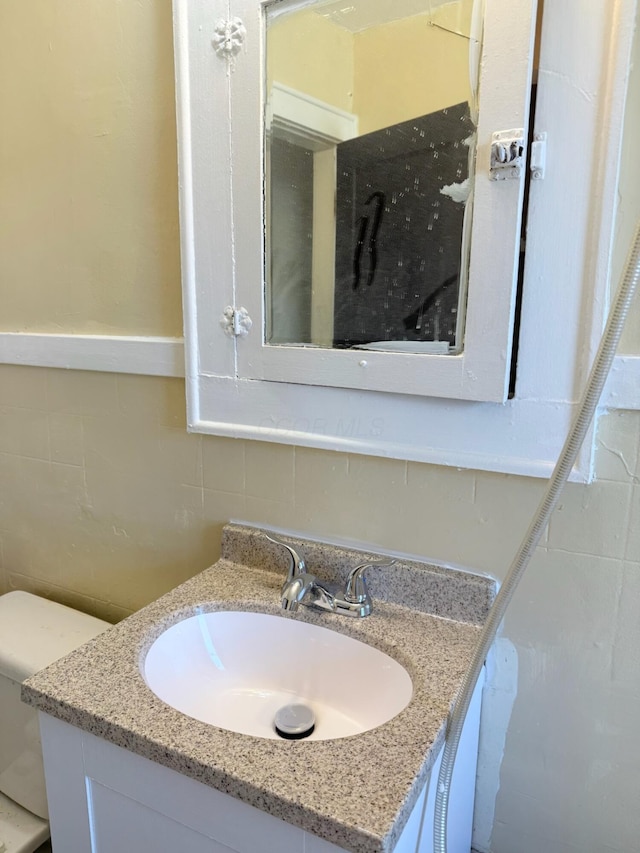 bathroom with tile walls and vanity