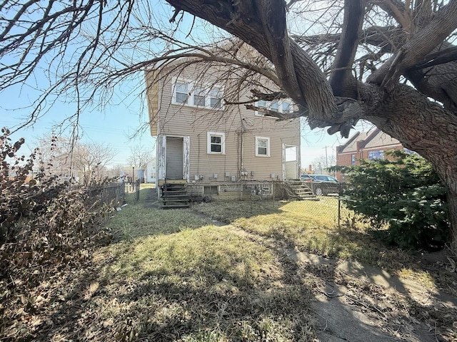 rear view of property featuring a lawn and fence private yard