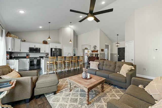 living room featuring wood finished floors, a ceiling fan, baseboards, and high vaulted ceiling