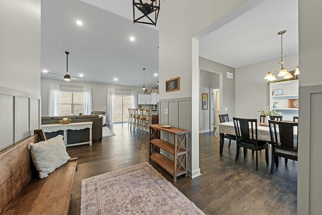 dining space featuring visible vents, recessed lighting, dark wood-style flooring, a towering ceiling, and ceiling fan with notable chandelier