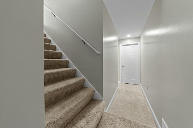 stairs featuring carpet flooring and baseboards