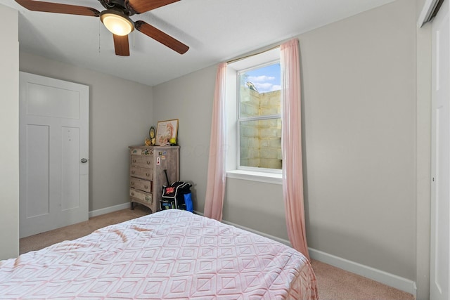 bedroom with baseboards, light carpet, and ceiling fan