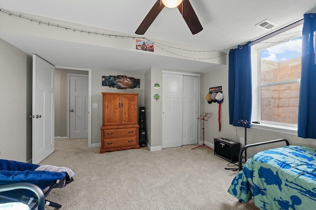 bedroom featuring carpet, visible vents, baseboards, ceiling fan, and a closet