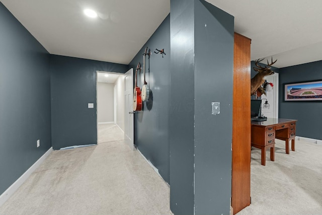 hallway featuring baseboards and light colored carpet