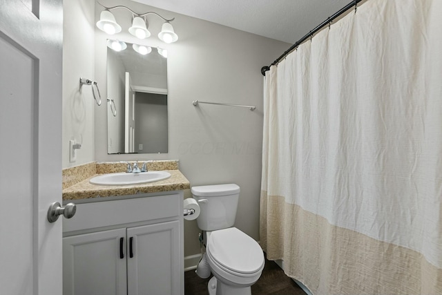 bathroom featuring a textured ceiling, toilet, vanity, and a shower with curtain