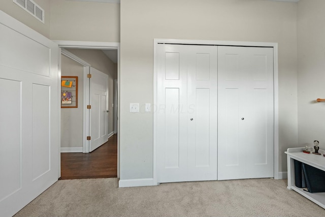 unfurnished bedroom with visible vents, baseboards, a closet, and carpet flooring