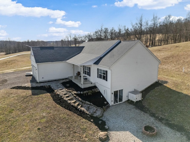 back of property featuring roof with shingles