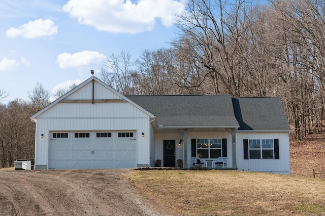 view of front of property with driveway, a front lawn, roof with shingles, and an attached garage