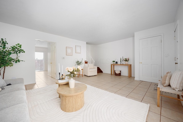 living room featuring light tile patterned flooring and stairs