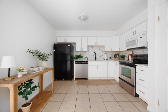 kitchen with light tile patterned floors, decorative backsplash, light countertops, white cabinets, and appliances with stainless steel finishes