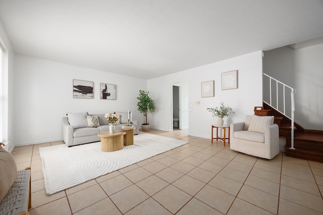 living room with light tile patterned flooring, stairway, and baseboards