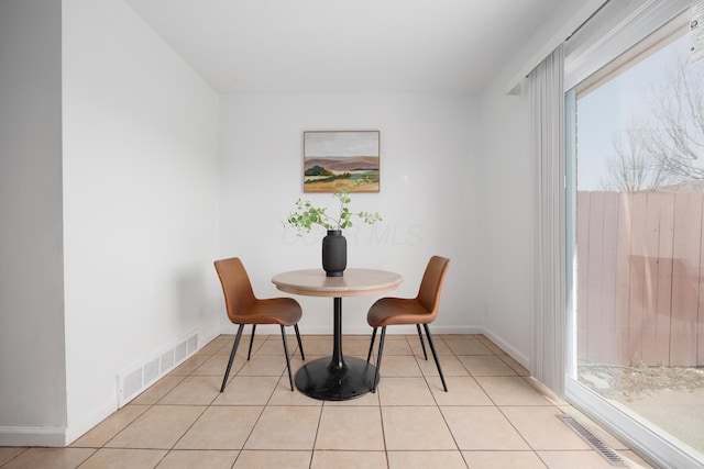 dining area with light tile patterned floors, baseboards, and visible vents