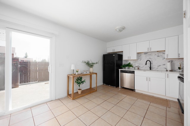 kitchen with backsplash, dishwasher, light countertops, freestanding refrigerator, and white cabinets