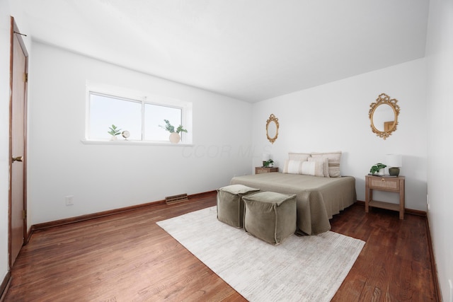 bedroom with baseboards and wood finished floors