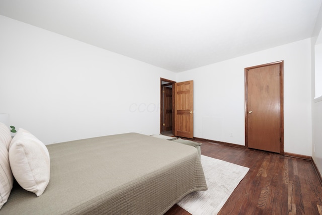 bedroom featuring dark wood finished floors and baseboards