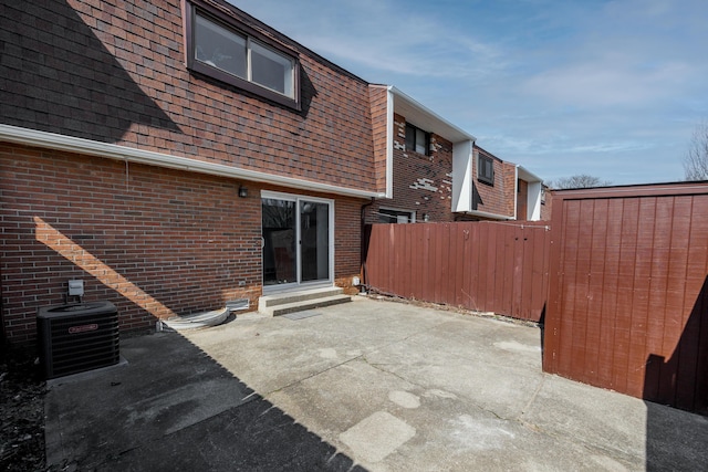 view of patio with entry steps, central air condition unit, and fence