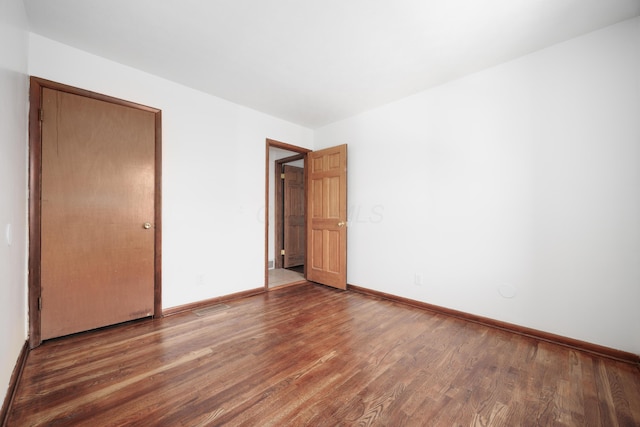 unfurnished bedroom featuring baseboards and wood finished floors