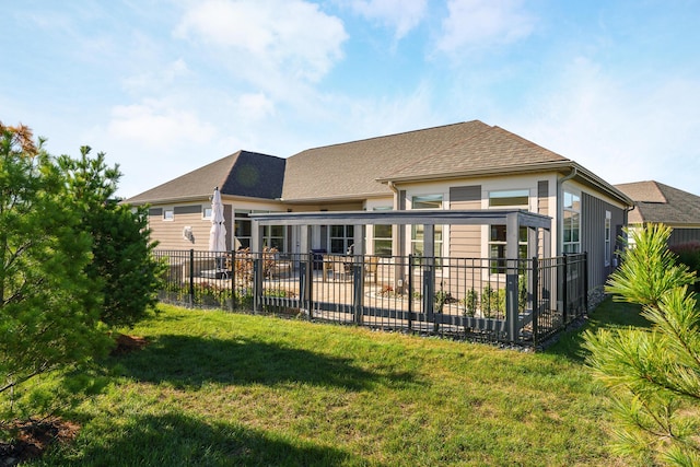 rear view of house with a yard, a patio, a shingled roof, and fence