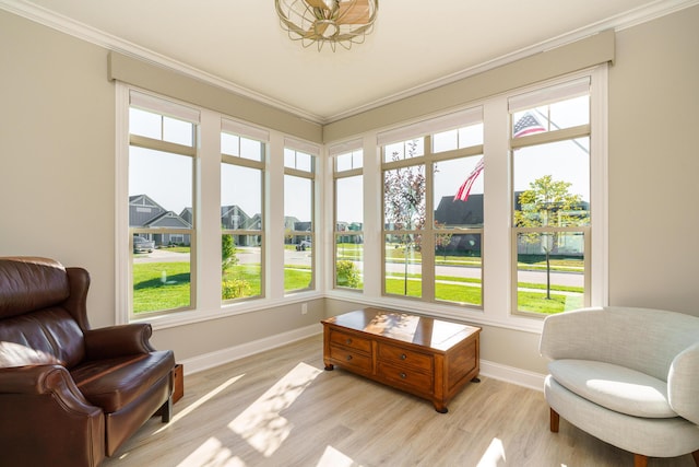 living area featuring light wood-style floors, baseboards, and ornamental molding