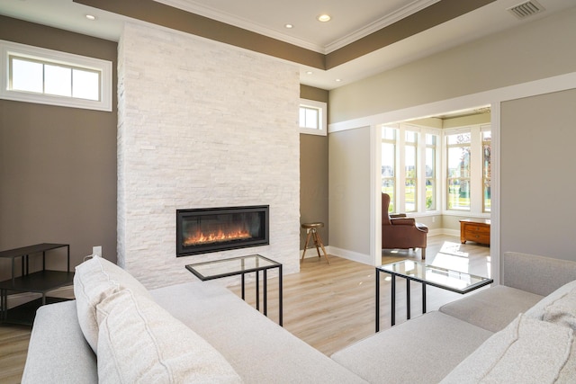 living room with a wealth of natural light, visible vents, light wood-style flooring, and a fireplace