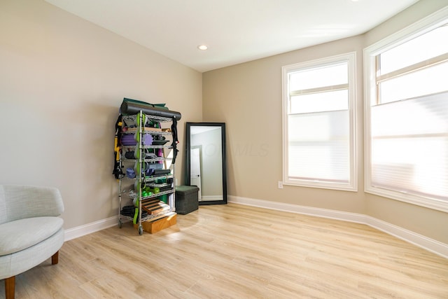 living area featuring light wood finished floors, recessed lighting, and baseboards