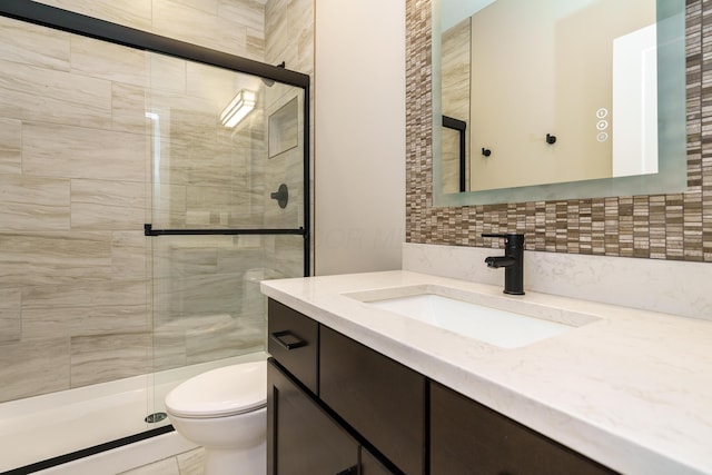 full bath featuring tasteful backsplash, toilet, vanity, and a shower stall