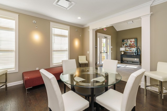 dining room featuring baseboards, lofted ceiling, ornamental molding, hardwood / wood-style floors, and ornate columns