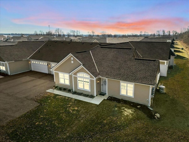 view of front of property with a garage, cooling unit, a residential view, and driveway