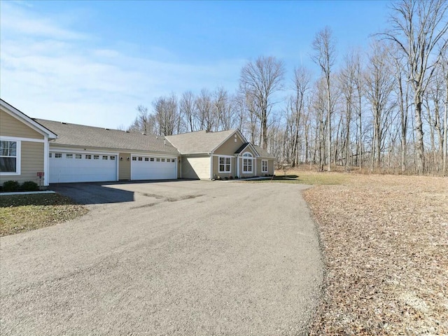 view of front facade with aphalt driveway and a garage