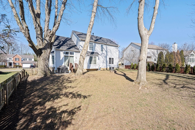 rear view of house featuring a residential view, a lawn, fence private yard, and entry steps