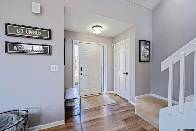 foyer entrance featuring baseboards and wood finished floors