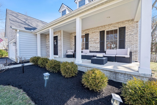 entrance to property with brick siding, an outdoor living space, and a porch